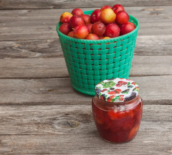 Jar of jam and a basket with red  plums — Stock Photo, Image