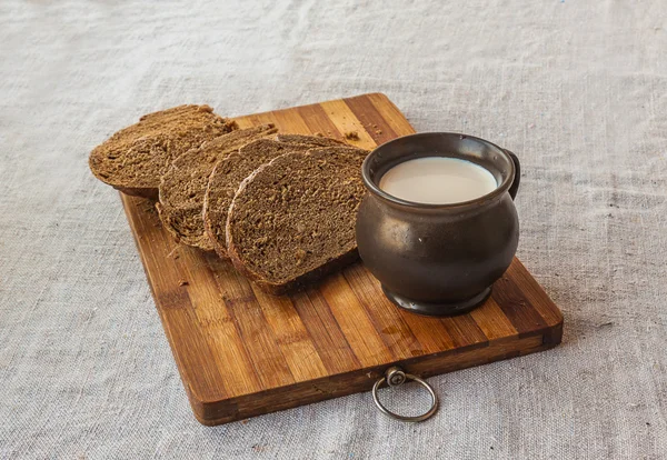 Hrnek mléka a žitný chléb — Stock fotografie