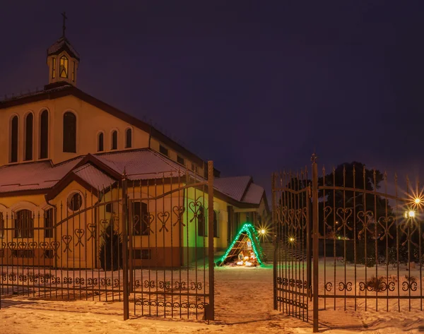 Julkrubba nära en kyrklig församling — Stockfoto