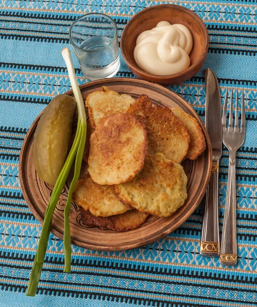 Potato pancakes, onions and glass of vodka — Stock Photo, Image