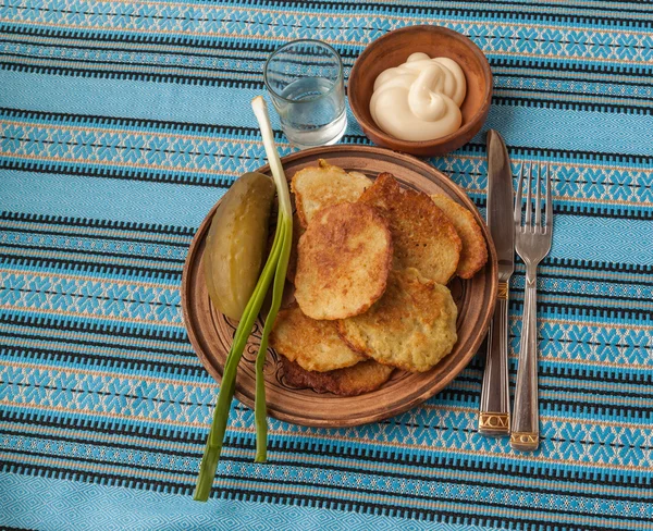 Aardappelpannenkoekjes, uien en glas wodka — Stockfoto