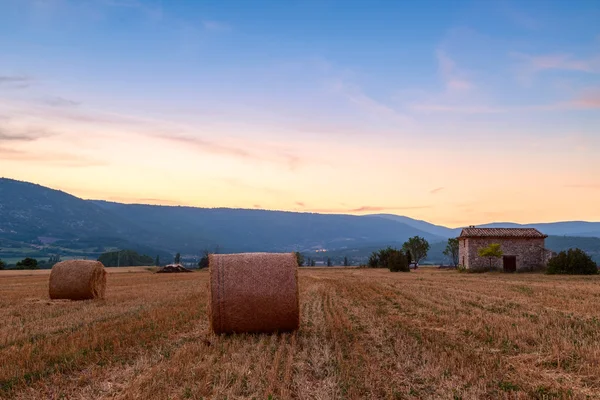 Puesta de sol sobre campo de granja con fardos de heno cerca de Sault —  Fotos de Stock