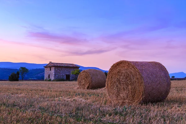 Sonnenuntergang über landwirtschaftlichem Feld mit Heuballen in der Nähe von Sault — Stockfoto