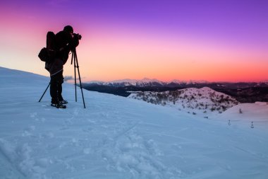 Nature photographer taking photos in the mountains clipart