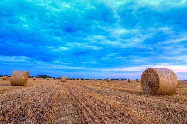 Sunset over rural road and hay bales — Stock Photo, Image