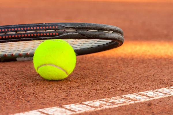 Pelota de tenis y raqueta en una pista de tenis de arcilla — Foto de Stock