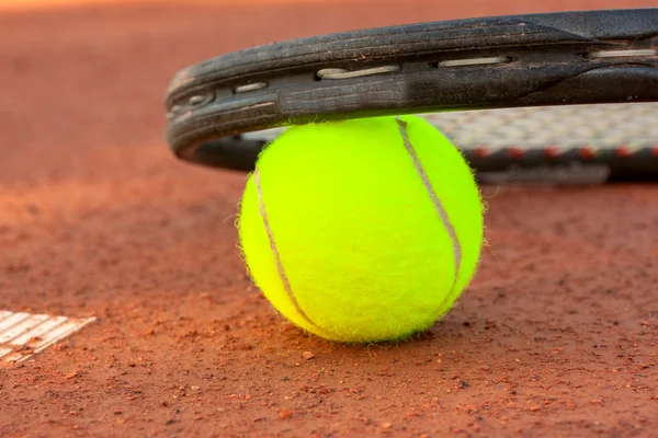Μπάλα τένις και ρακέτα σε γήπεδο τένις πηλό — Φωτογραφία Αρχείου