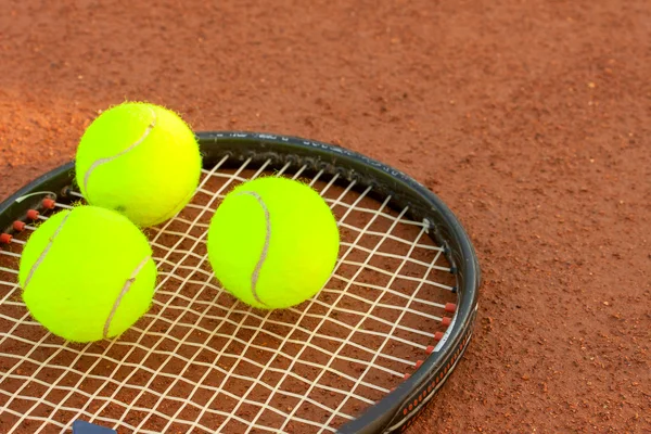 Pelota de tenis y raqueta en una pista de tenis de arcilla — Foto de Stock