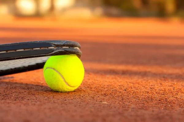 Μπάλα τένις και ρακέτα σε γήπεδο τένις πηλό — Φωτογραφία Αρχείου