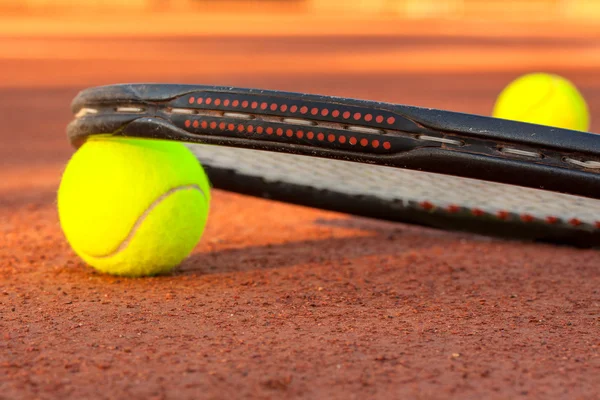 Pelota de tenis y raqueta en una pista de tenis de arcilla — Foto de Stock