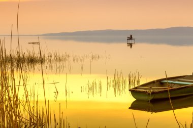 Sunset on the lake Balaton with a boat clipart