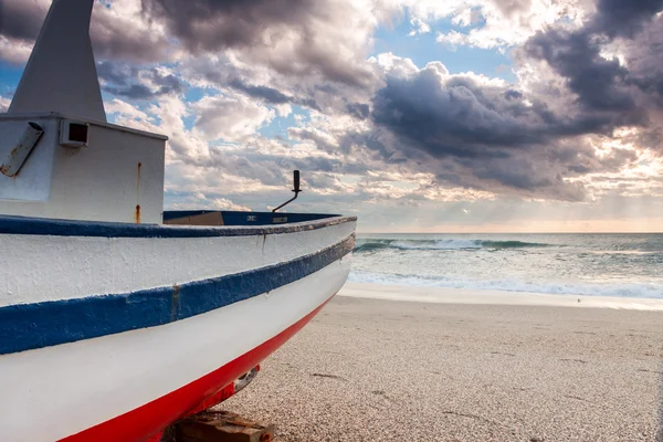 Човен на пляжі під час заходу сонця — стокове фото