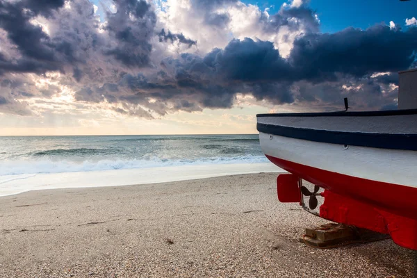 Båt på stranden ved solnedgang – stockfoto