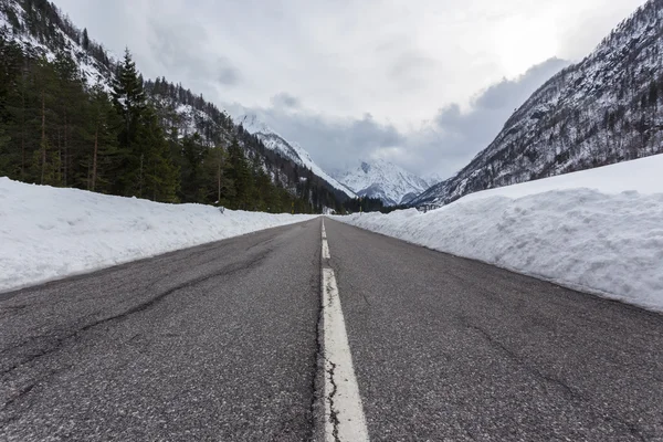 Estrada de montanha vazia em um dia nublado de inverno — Fotografia de Stock