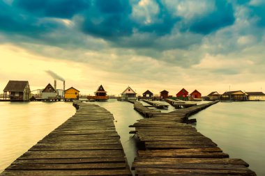 Gün batımı göl Bokod iskele ve Balık tutma ahşap evler ile