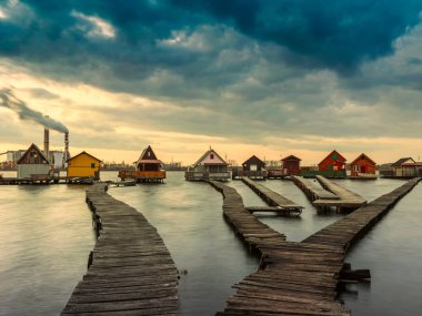 Gün batımı göl Bokod iskele ve Balık tutma ahşap evler ile