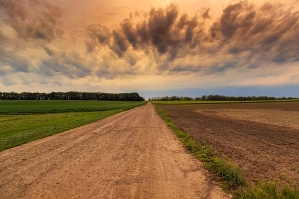 Estrada suja para o céu dramático — Fotografia de Stock