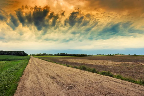 Estrada suja para o céu dramático — Fotografia de Stock