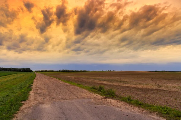 Estrada suja para o céu dramático — Fotografia de Stock