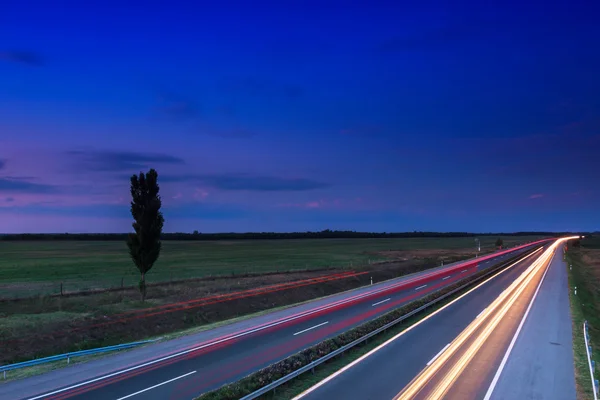 Carros acelerando em uma estrada — Fotografia de Stock