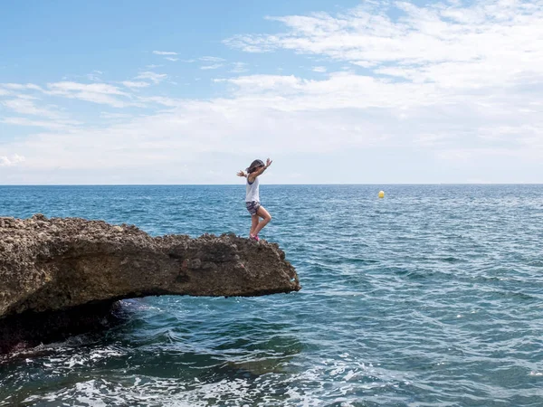 海の岩の上に立つ女性の側面図 — ストック写真