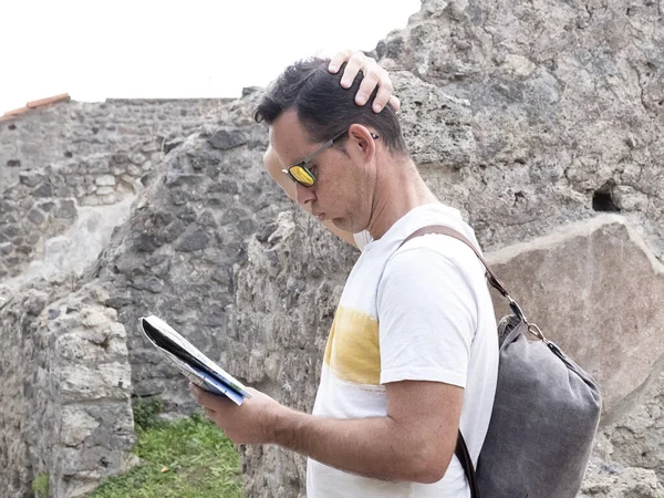 困惑的背包客在查看旅游地图的同时探索着古老的废墟 — 图库照片