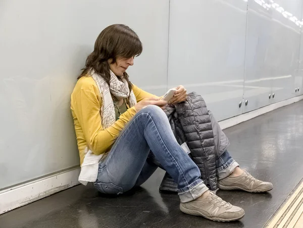 Mujer Joven Sentada Suelo Usando Teléfono Mientras Apoya Pared Plataforma — Foto de Stock