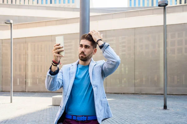 Красивый Молодой Человек Улыбается Пользуется Мобильным Телефоном — стоковое фото