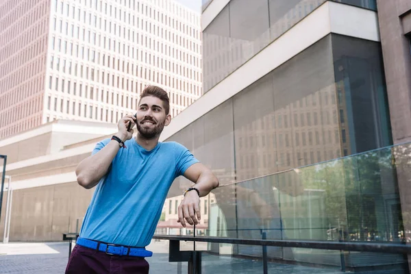 屋外に立っている間に電話や笑顔で話す陽気な現代のビジネスマン — ストック写真