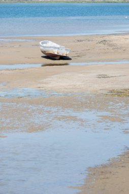 Islak kumsalda eski bir kayık.