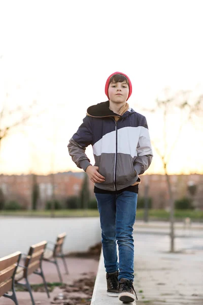 穿着斜纹棉布夹克 头戴针织帽子的英俊少年男子紧跟城市背景 — 图库照片