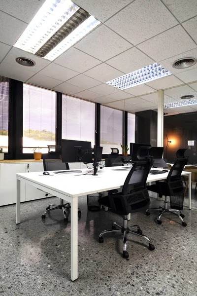 Modern open space office with computer monitors on white desks — Stock Photo, Image