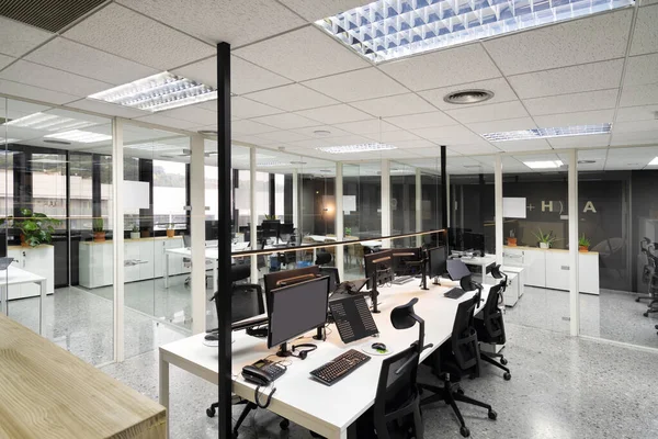 Moderna oficina de espacio abierto con monitores de computadora en escritorios blancos — Foto de Stock