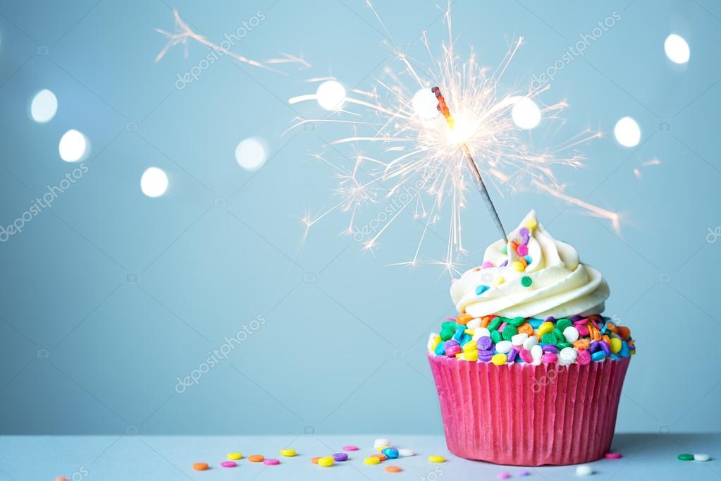 Cupcake with sparkling candle for 39th birthday or anniversary with big  number in white with yellow streamers on blue table with dark background  full Stock Photo - Alamy