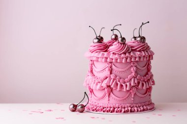 Eski tarz tereyağlı fırfırlı ve kirazlı süslü doğum günü pastası.