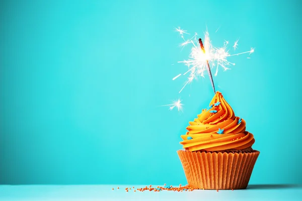 Oranje cupcake met sparkler — Stockfoto