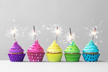 Colorful cupcakes with sparklers clipart