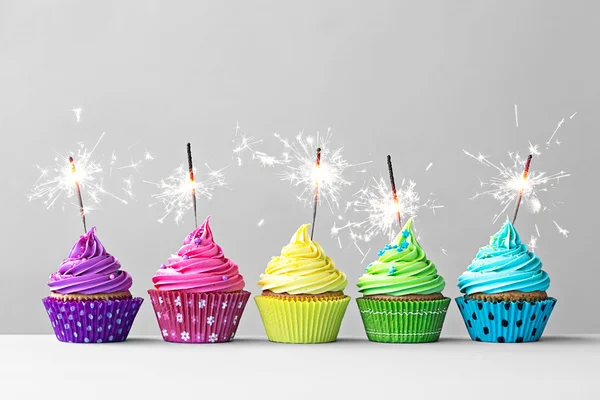 Colorful cupcakes with sparklers — Stock Photo, Image
