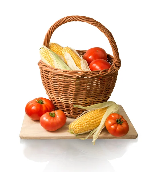 Cobs of corn and tomatoes in basket — Stock Photo, Image