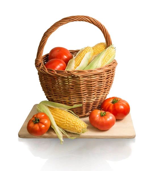 Cobs of corn and tomatoes in basket — Stock Photo, Image