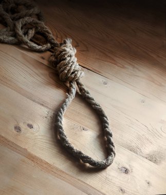 Boş antika hapishane hayatı öldürücü büküm yaka ahşap masa boşluğu asılı. Yakından bakıldığında karanlık, zalim, kaba, üzgün adam Juda, idam kanunu iplikçik düğümünün kötüye kullanılmasından korkuyor.