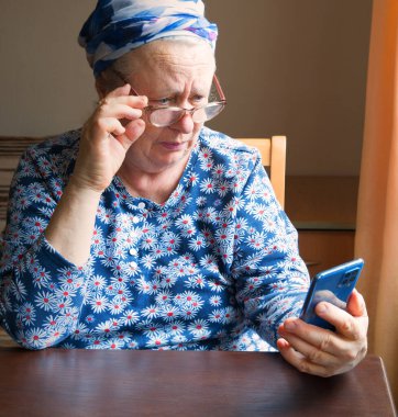 Kayıp, üzgün, yaşlı bayan müşteri göz yanılması yaşıyor. Ödeme satışı şüphesiyle sohbet sayfası mesajlarının el optiği lensleri kullandığını görüyor. Tek başına üzgün insan kolu tut, modern tablet yazıları al.