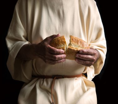 Lezzetli taze, beyaz, yuvarlak arpa taneli çörek ekmeği aç kız çocuğunun çalışmasına yardımcı olur. Kapalı eski erkek tanrı İsa kol inancı sıcak kabuklu çavdar diyeti mutfağı retro İncil karanlık ev metni alanı