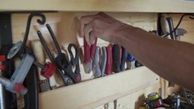 Ahşap işçilerinin elleri atölyedeki marangozluk aletlerini seçiyor. DIY kavramı.