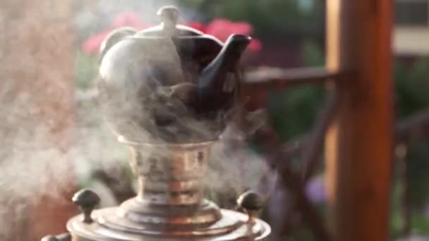 蒸気でロシアのサモバルを沸騰させ 上にティーポットを醸造して閉じます カントリーハウスのテラスでティーパーティー — ストック動画