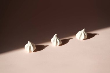 Çapraz sıra tatlı kremalı pasta ya da gölgeli pastel pembe arka planda marşmelov. Minimalizm gıda konsepti.