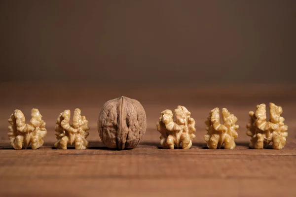 Baris Kenari Lima Dikupas Dan Satu Shell Meja Kayu Cokelat — Stok Foto