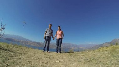 Yavaş hareket: çift el ele tutuşarak ve Özbekistan'a Charvak Gölü yakınındaki atlama turist.