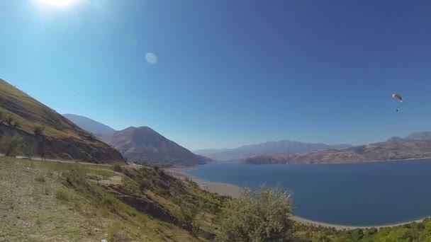 Panorama Charvak meer met paraglider overheen, Oezbekistan. — Stockvideo