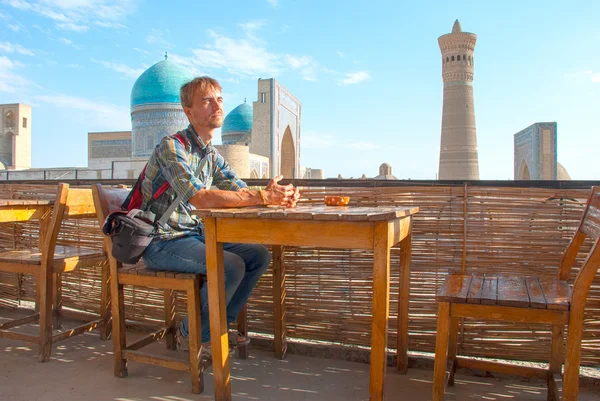 Turista sentado em um telhado-casa de chá na cidade velha de Bukhara — Fotografia de Stock